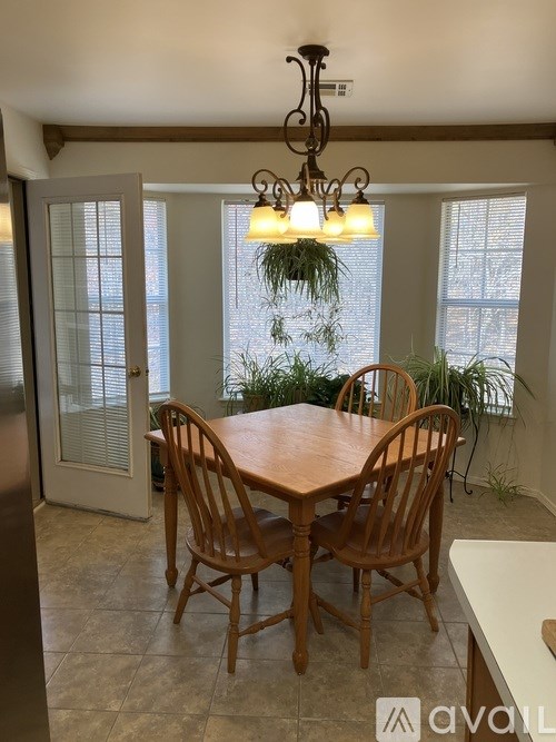 A dining room with a wooden table and chairs.