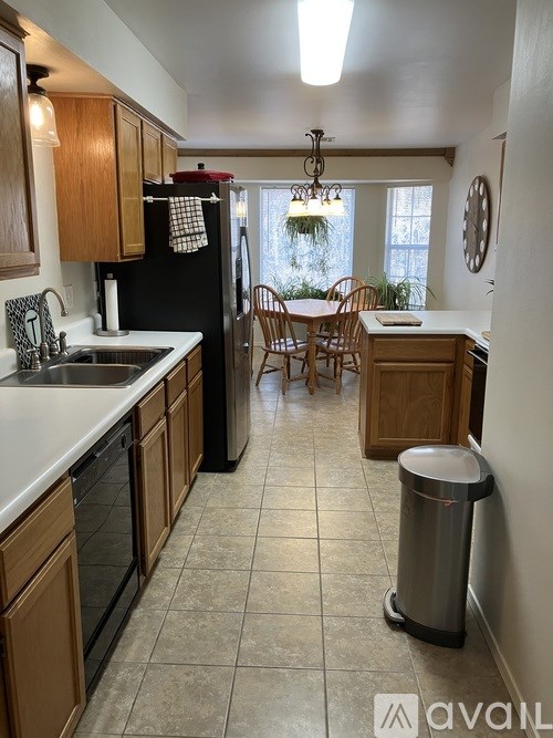 A kitchen with wooden cabinets and a black refrigerator.