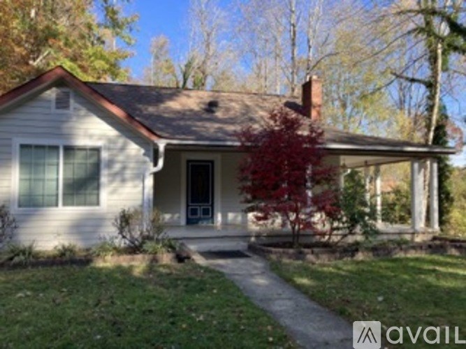 A house with a red tree in front of it.