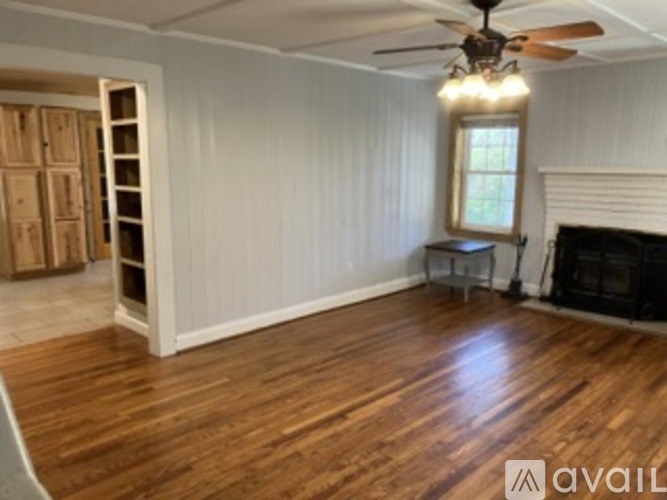 A room with wooden floors and a ceiling fan.