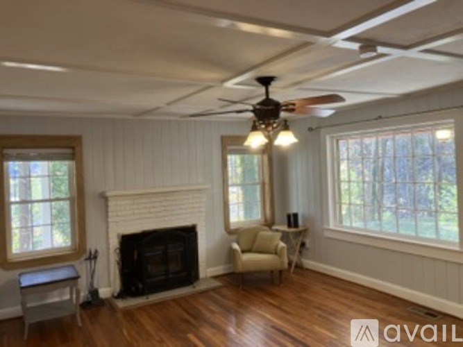 A living room with a fireplace and a ceiling fan.