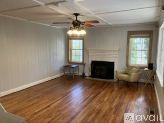 A living room with a fireplace and a ceiling fan.