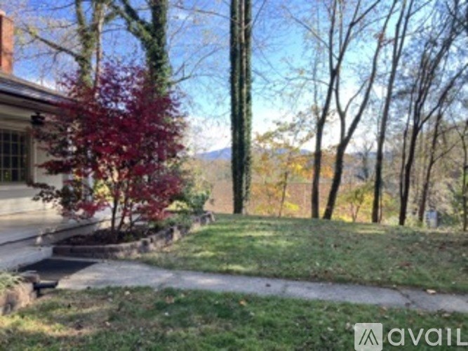 A house with a red tree in front of it.