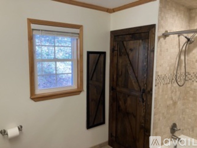 A bathroom with a wooden door and a window.