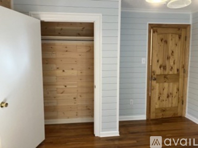 A room with a white door and a wooden door.