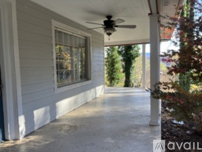 A porch with a ceiling fan and a window.