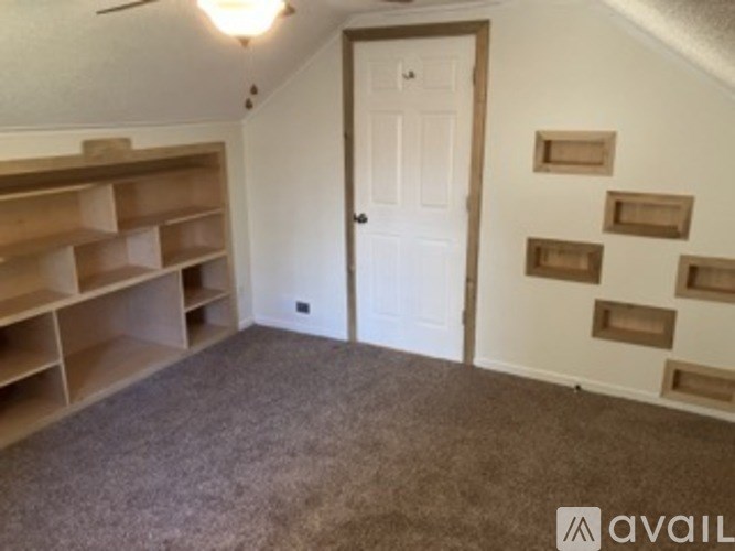 A room with a white door and a carpeted floor.