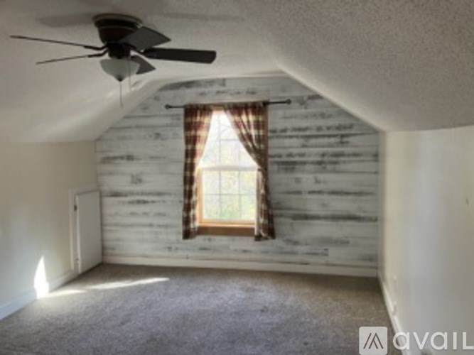 A room with a window and a ceiling fan.