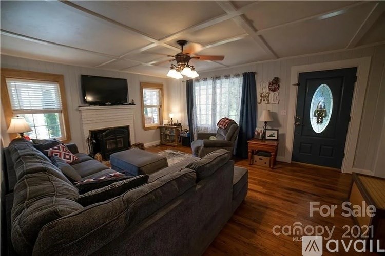 A living room with a grey couch and a fireplace is for sale.