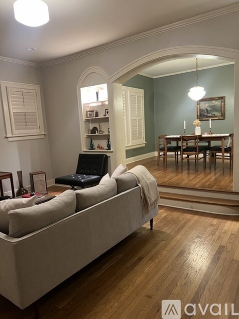 A living room with a couch, a table, and a painting on the wall.