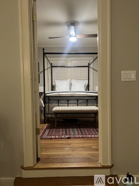 A bedroom with a bed and a rug on the floor.