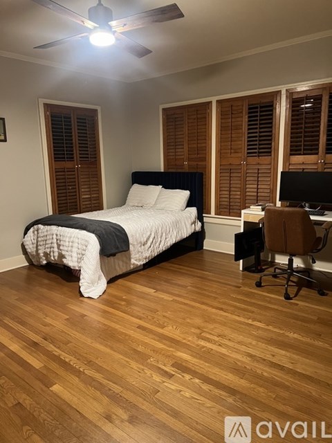 A bedroom with a bed, chair, and desk.