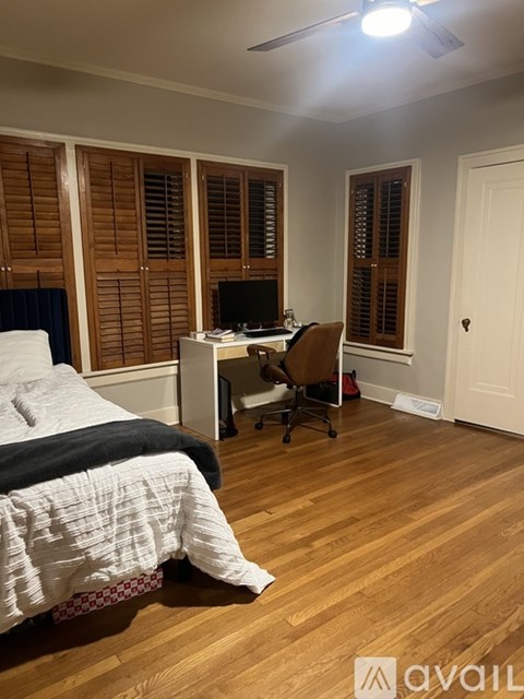 A bedroom with a bed, desk, and chair.