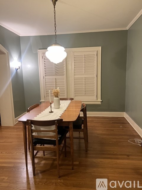 A dining room with a wooden table and chairs.