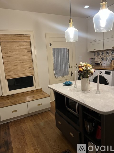 A kitchen with a wooden floor and white walls.
