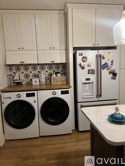 A kitchen with a refrigerator covered in magnets and a washing machine.