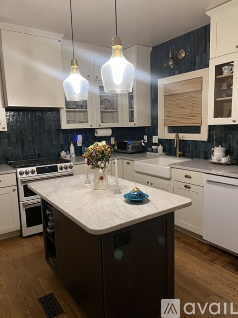 A kitchen with a marble countertop and a vase of flowers on it.