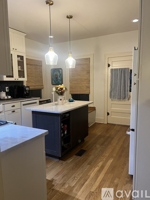 A kitchen with wooden floors and a white countertop.