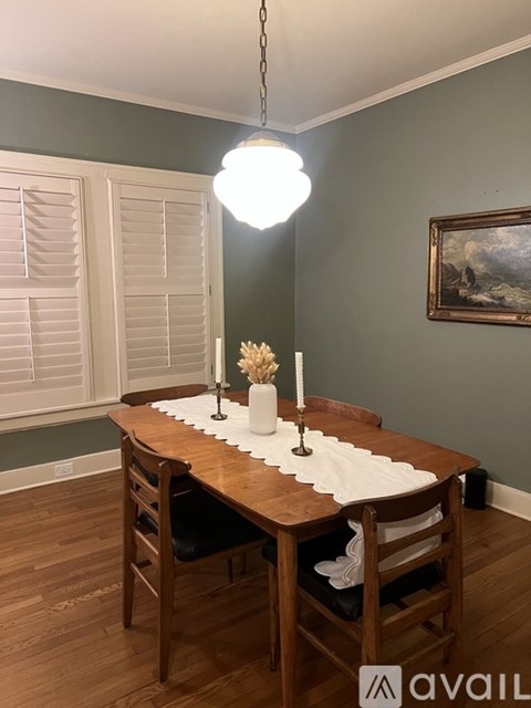 A dining room with a wooden table and chairs.