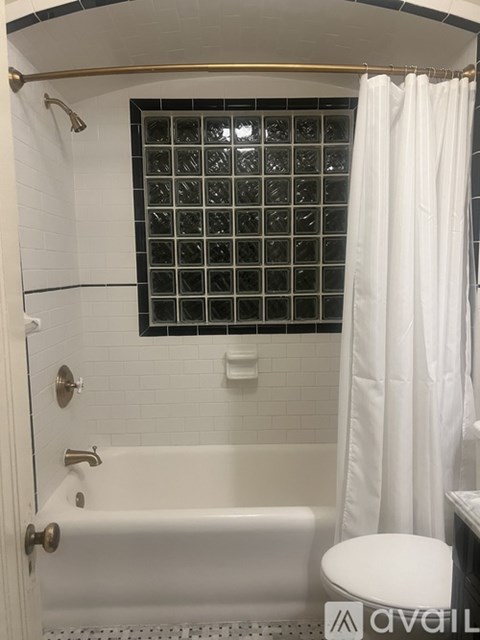 A white bathroom with a white tub and shower curtain.