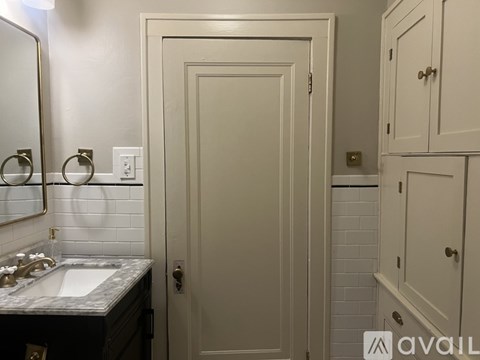 A bathroom with a sink, mirror, and cabinets.