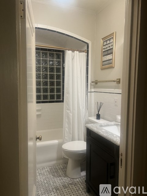 A bathroom with a toilet, sink, and shower.