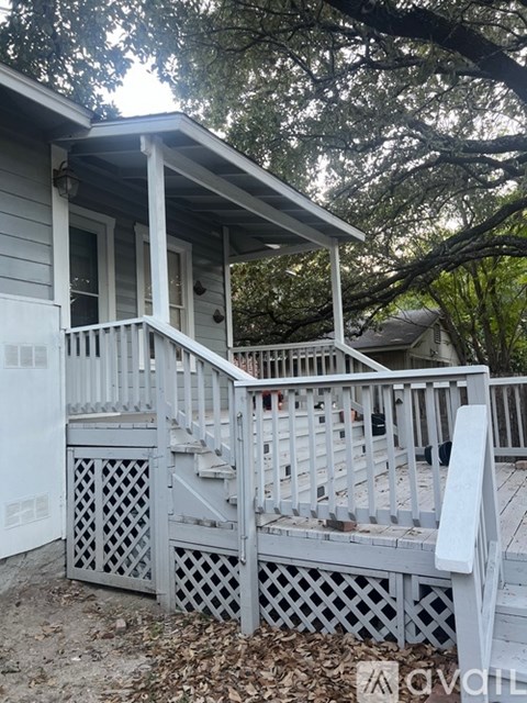 A porch with a lattice design on the railing.