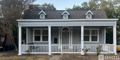A white house with a porch and a sign that says "available".