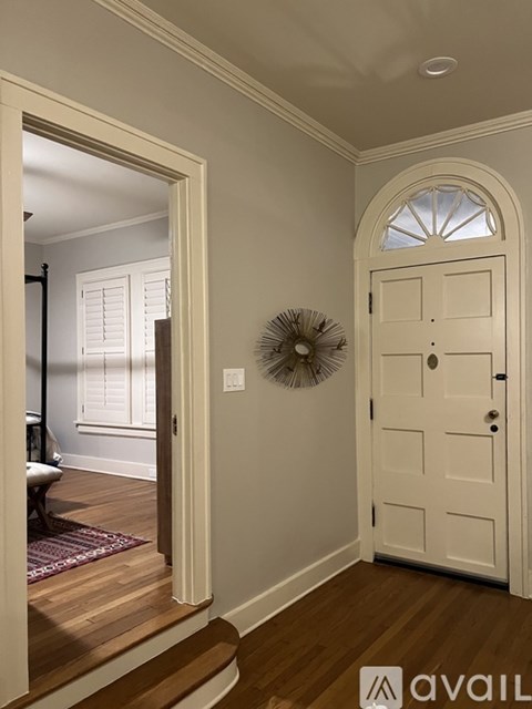 A white door with a fan on the wall.