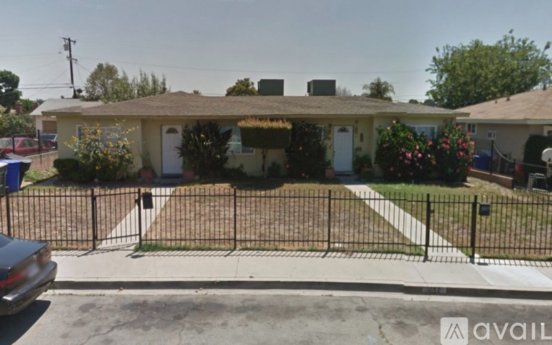 A house with a white door and a black fence.