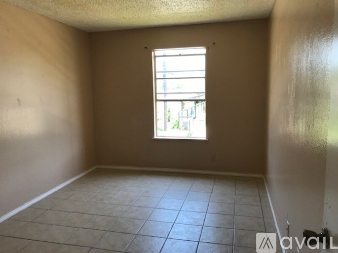 Empty room with a window and tiled floor.