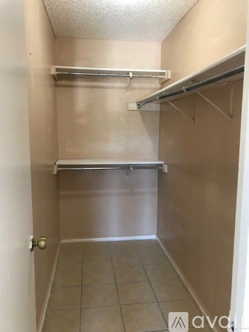 A small, empty room with a door and a shelf.