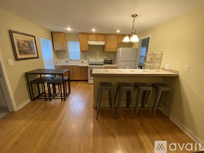 A kitchen with wooden floors and a refrigerator.