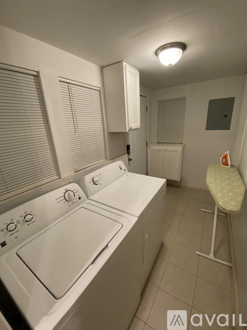 A small, white, laundry room with a washer and dryer.