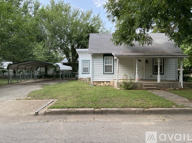 A white house with a porch and a covered patio area.