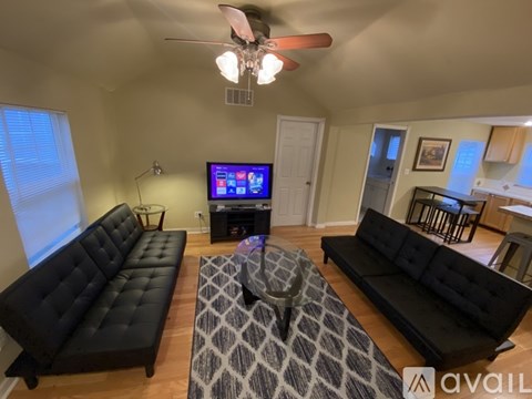 A living room with black couches and a television.