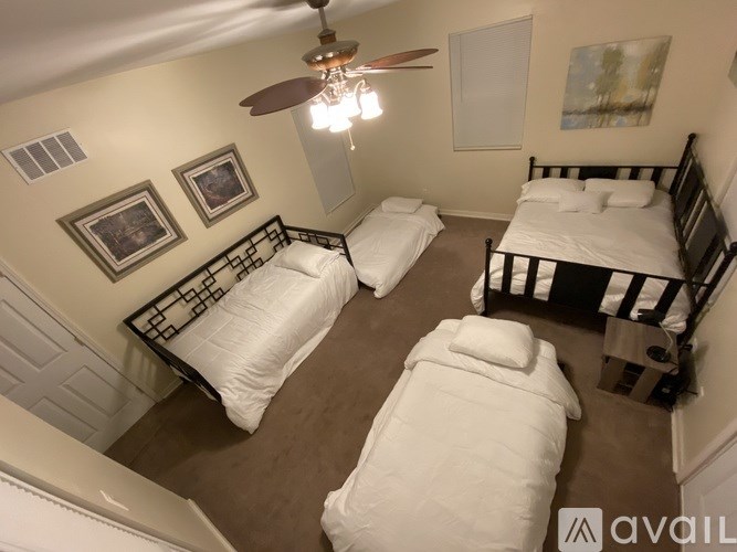 A room with two beds and a ceiling fan.