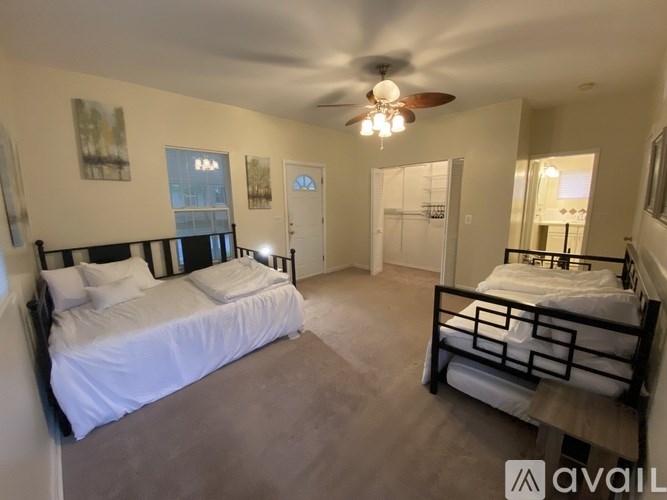 A bedroom with two beds and a ceiling fan.