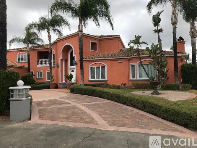 A house with a red exterior and a driveway in front.