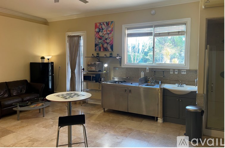 A kitchen with a refrigerator, sink, and stove.