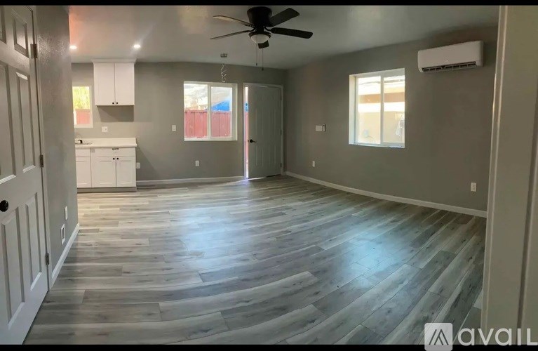A room with wooden flooring and a ceiling fan.