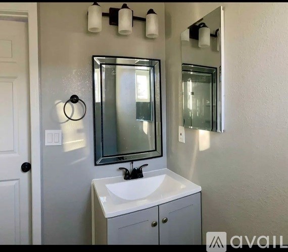 A bathroom with a white sink and a mirror above it.