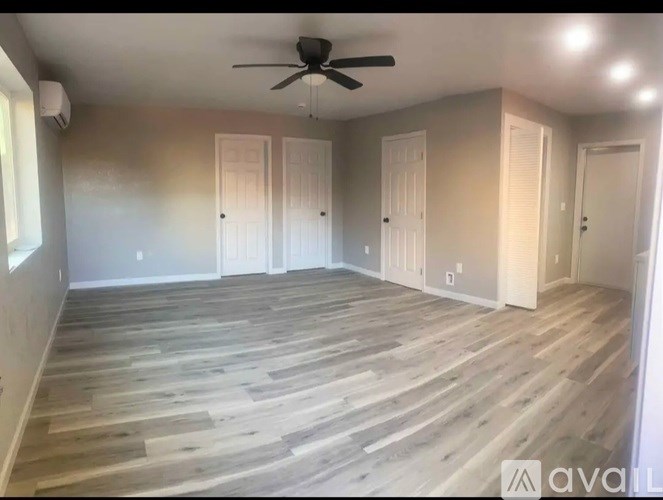 A room with wooden flooring and a ceiling fan.