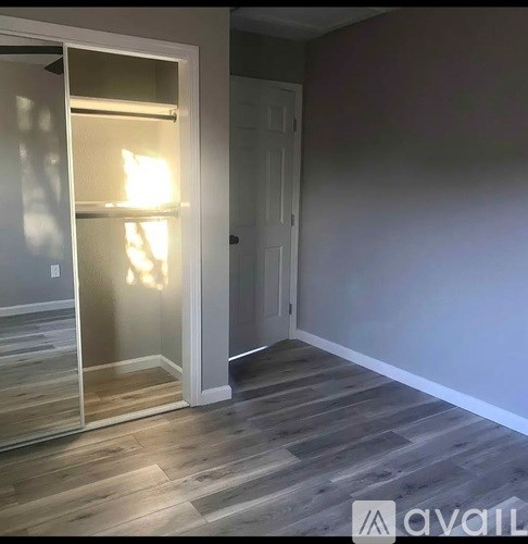 A room with a wooden floor and a white door.
