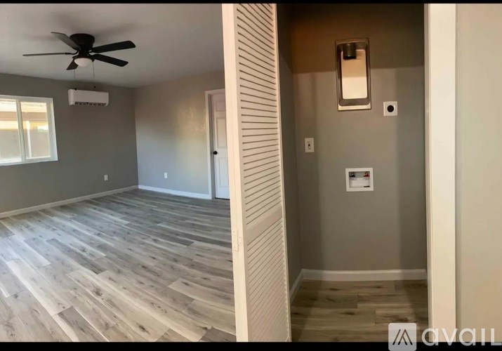 A room with a ceiling fan and wooden flooring.
