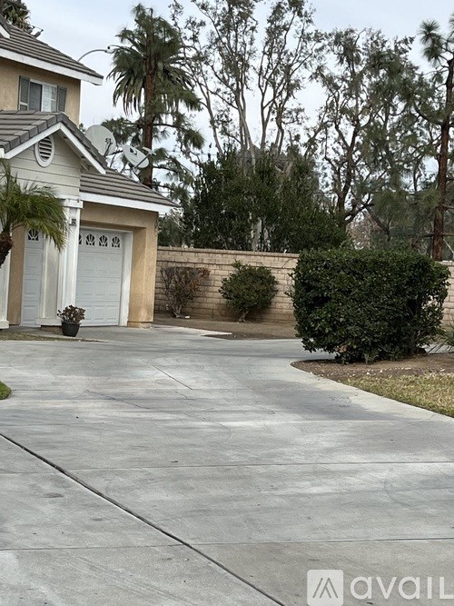 A house with a driveway and a tree in front.