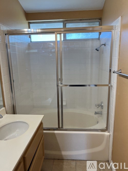 A bathroom with a glass shower door and a white sink.