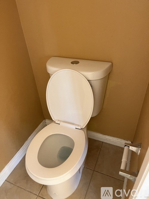 A toilet with the seat up in a small bathroom.