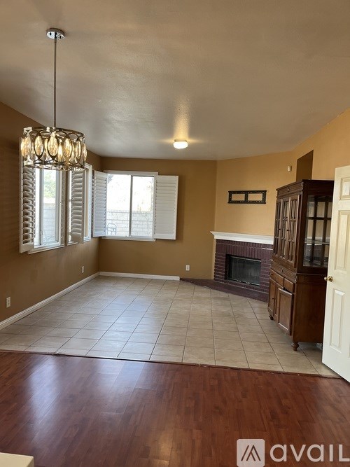 A living room with a fireplace and a chandelier.