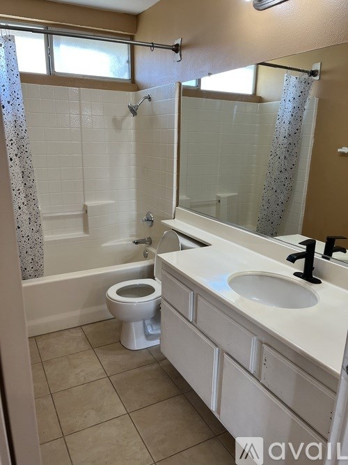 A bathroom with a toilet, sink, and shower.